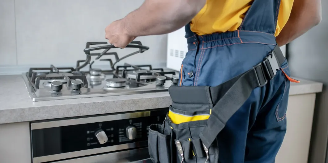 فنى صيانة افران بالرياض يقوم بفحص فرن غاز في المطبخ
