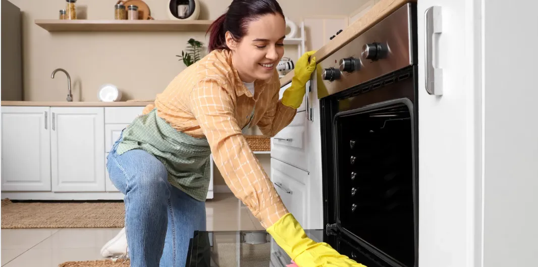 أخصائي صيانة وفني تنظيف افران بالرياض أثناء العمل على فرن حديث.
